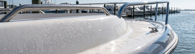 White boat's hull and chrome railings covered in hard water spots