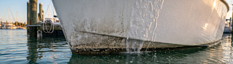 White boat hull with visible waterline grime and rust streaks