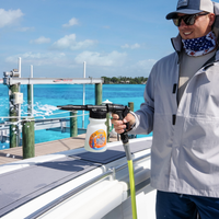 Man using the Salty Dog boat cleaning sprayer to rinse saltwater off a boat at a marina